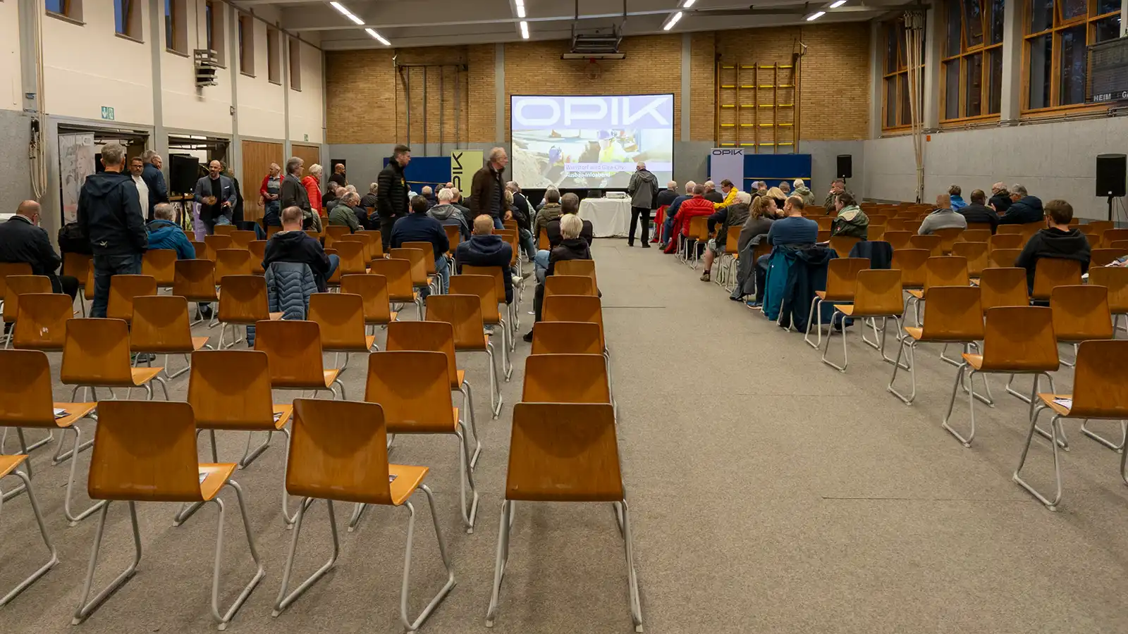 Konferenztechnik-Setup von PVD Events in einer Turnhalle in Wunstorf: Panasonic Laser-Beamer, große Rahmenleinwand und Lautsprecher-System.