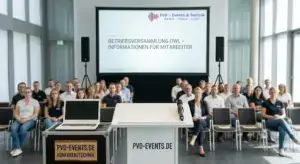 Professionelles Setup für eine Betriebsversammlung mit Rednerpult, Sennheiser Funkmikrofon, großer Leinwand und Beschallungsanlage in einer Firmenlocation in OWL.