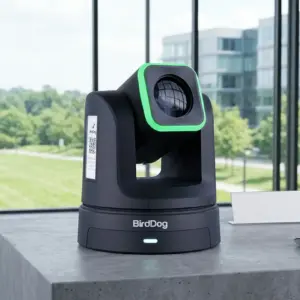 BirdDog X4 Ultra Black PTZ-Kamera mit grün leuchtendem Halo-Ring auf einem Betonschreibtisch in Hüllhorst, OWL, zur Miete.