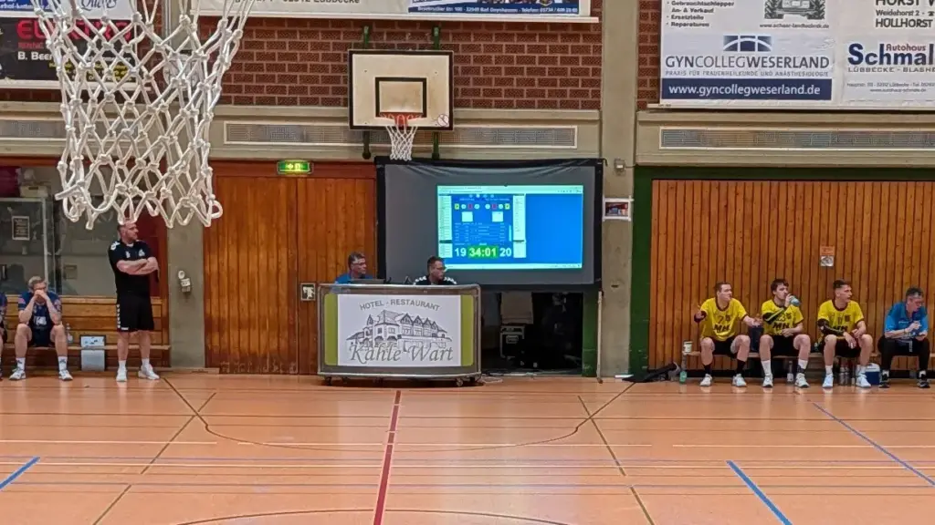 Eine mobile Rückpro-Leinwand zeigt die Spielstandanzeige eines Handballspiels in der Sporthalle Hüllhorst, improvisiert durch PvD - Events & Technik mittels Beamer-Projektion.
